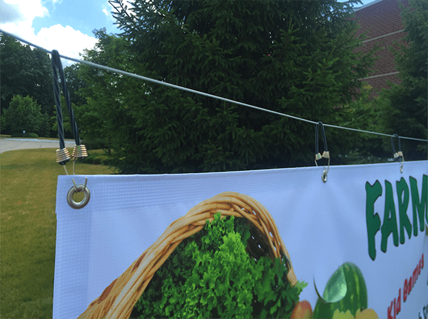 bungee cords or springs help keep the banner tight and wrinkle-free